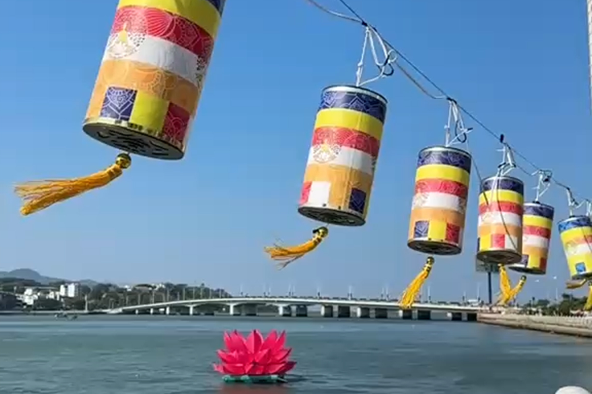 Vibrant Buddhist lanterns hanging in precise sequence along a guiding wire over the water in Nha Trang, Vietnam—a visual metaphor for lifestyle architecture and commercial alignment, showing how clear business objectives and goals create an unburdened path to personal freedom.
