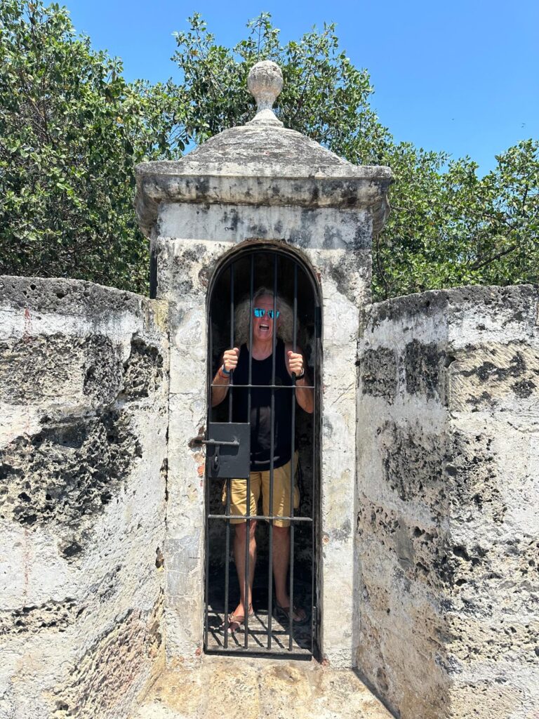 Locked behind an iron gate within the walls of a historic Cartagena, Rik Lambert acts out the crushing daily pressure of business owner burnout. © Gil Devlin 2024