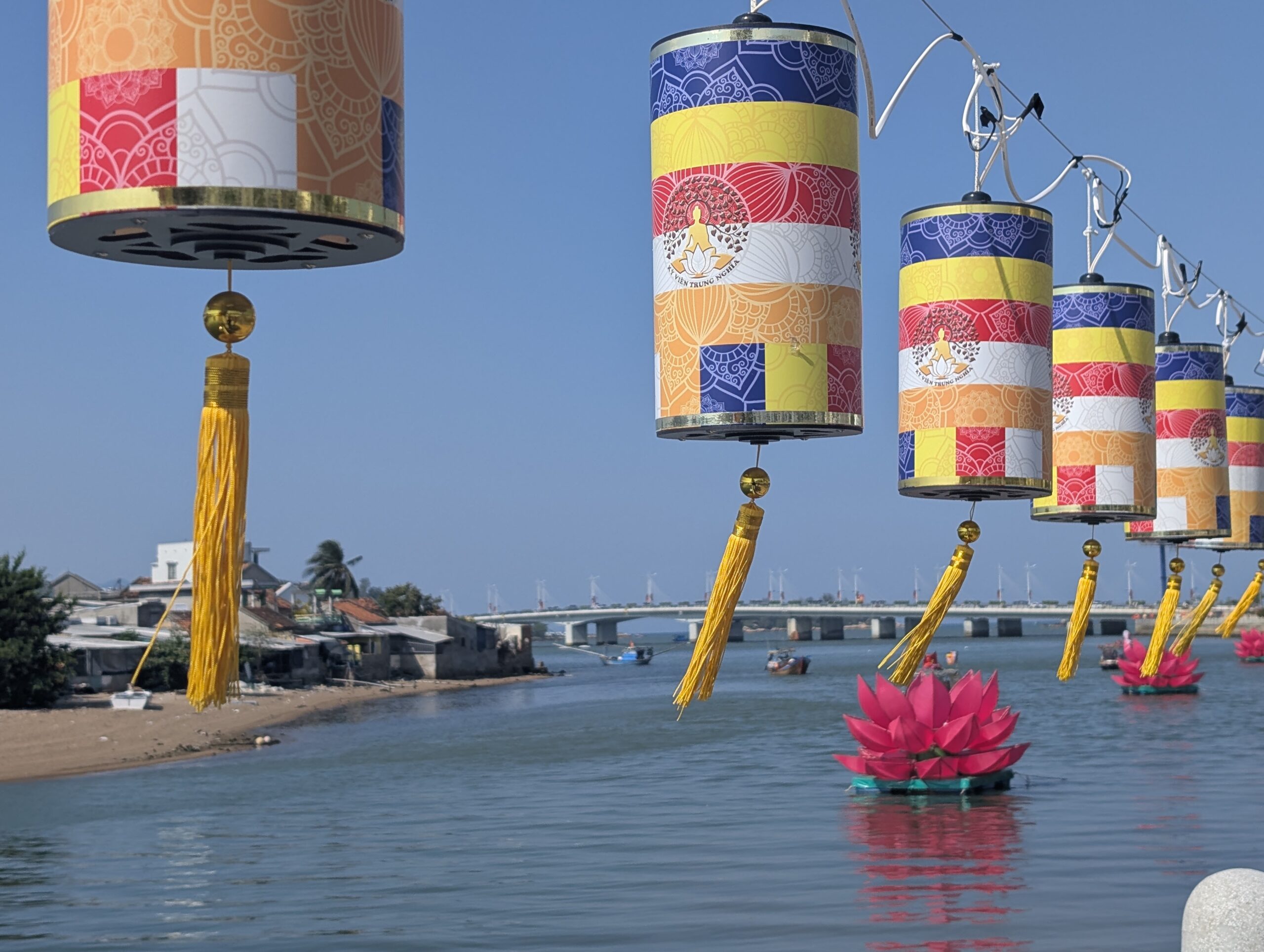 Vibrant Buddhist lanterns hanging in precise sequence along a guiding wire over the water in Nha Trang, Vietnam—a visual metaphor for lifestyle architecture and commercial alignment, showing how clear business objectives and goals create an unburdened path to personal freedom.