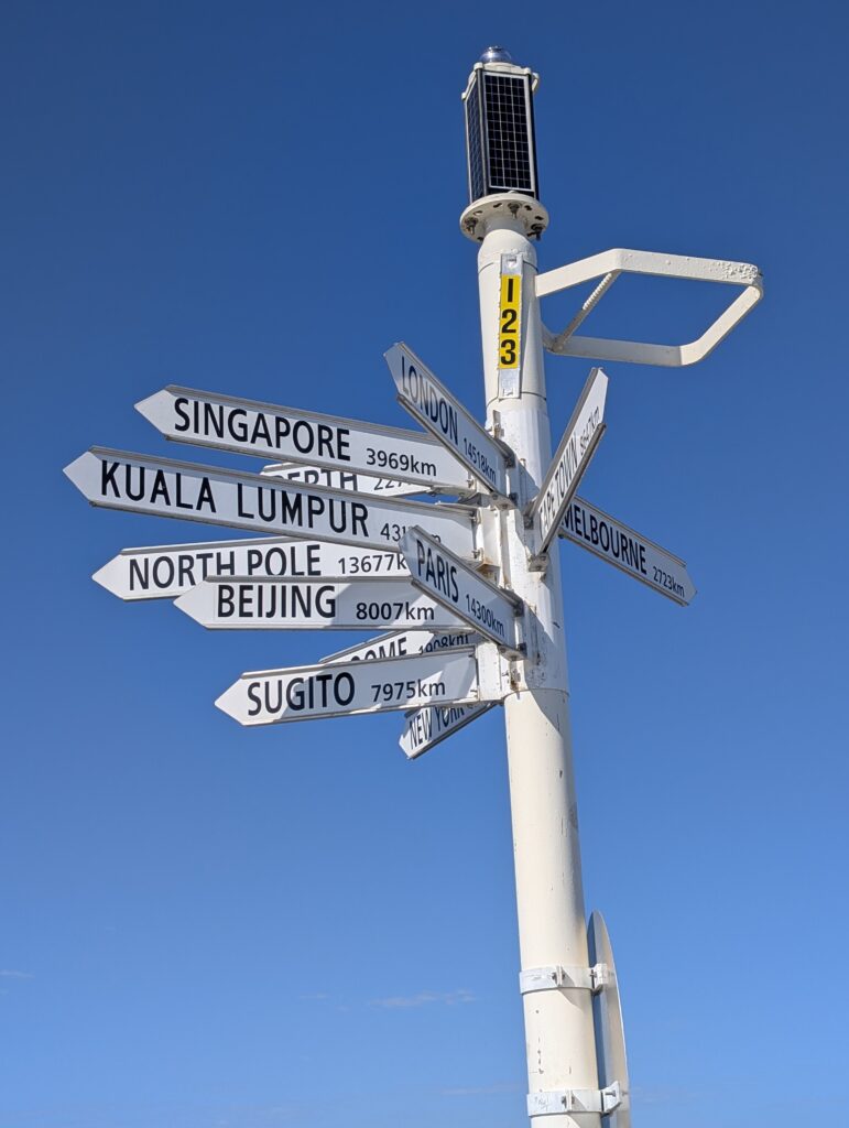 A signpost on Busselton Jetty pointing to dozens of global locations. This represents an unvetted list of secondary goals to avoid at all costs. © Rik Lambert 2026