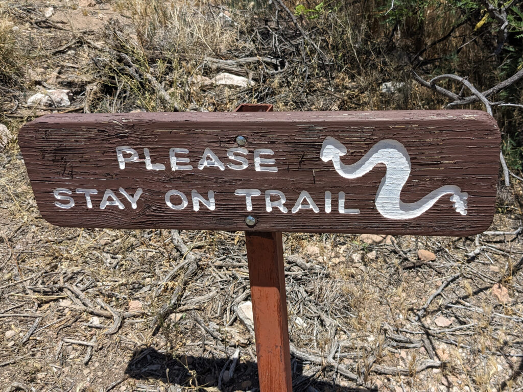 A wooden trail marker sign in Santa Fe illustrating accountability and staying on track with support from a high-performance business coach.