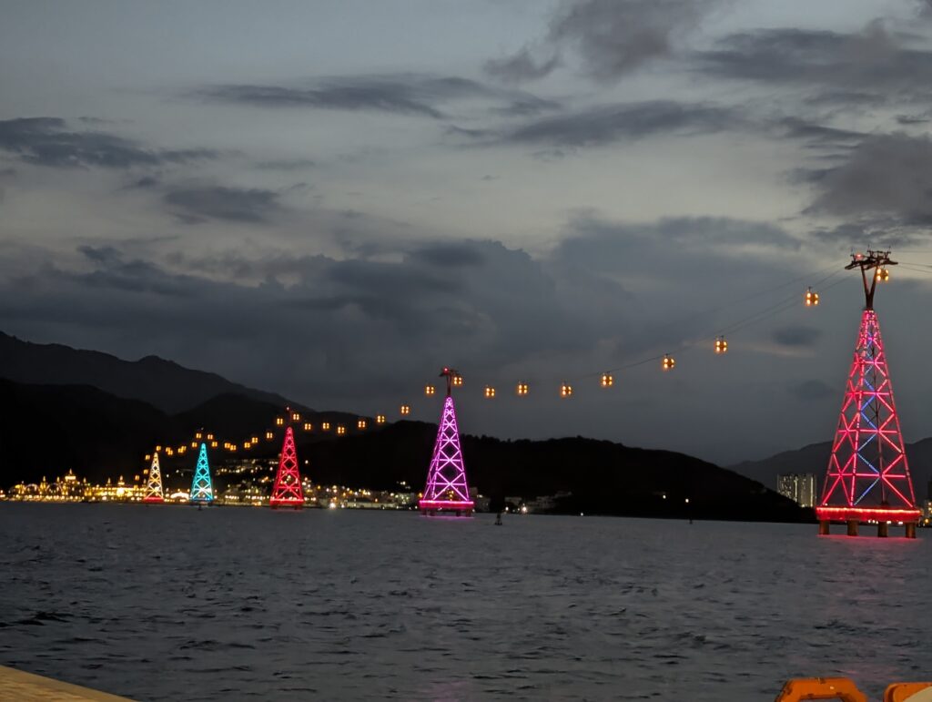 An illuminated line of cable car towers across the sea at Nha Trang, Vietnam. This symbolises clear communication passing seamlessly between leaders and employees.